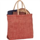 Red herringbone tote bag with handles, containing a notebook and dark cloth.