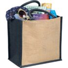 A tote bag filled with sunglasses, a floral scarf, a book, and a rolled-up magazine.