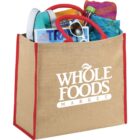 Whole Foods Market tote bag filled with magazines, sunglasses, and water bottle.