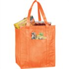 Orange reusable bag with groceries, including box and jars, on a white background.