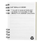 Notepad with goals: increase sales, hire 500 employees, reduce customer complaints.