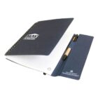 Open blue notebook with pen in holder, lined pages, and MAV Scholars text on cover.
