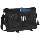 Black messenger bag with pens, a phone, and a notebook in its front and main pockets.