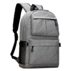 A gray backpack with a sleek, minimalist design. It has a front zippered pocket, adjustable shoulder straps, and side mesh pockets. The backpack is standing upright on a plain white background.