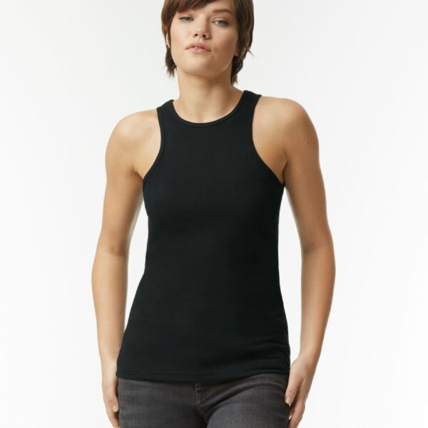 Person wearing a black sleeveless top and dark jeans standing against a plain white background.