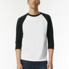 Person wearing a white and black raglan shirt and dark jeans, standing against a plain background.