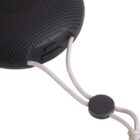 Black portable speaker with a power button and a white carrying cord.