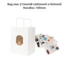 White gift bag with bear design, surrounded by colorful sticker sheets.