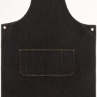 A plain black denim apron with visible brown stitching, featuring a large rectangular pocket in the center. It has metal eyelet accents on the top corners and shoulder areas.