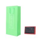 Green gift bag with AIR MAIL text and red-edged stamp on white background.