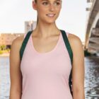 Person in a pink tank top with a backpack, standing by a river and bridge.