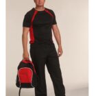 Man in black and red sportswear holding a backpack, standing against a beige background.