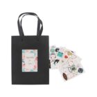 Black gift bag with floral card, surrounded by various colorful stickers.