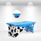 Table with a blue and cow-print cover, displaying the word choco.