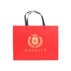 Red shopping bag with Royalty and a crowned R emblem on front.