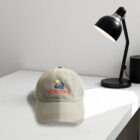 A beige cap with a logo on a white desk near a black lamp.