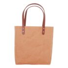 Brown paper tote bag with leather handles against a white background.
