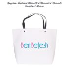 White tote bag with Ben Betesh in blue and pink text. Black handles.