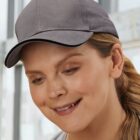 Person in a gray cap smiling indoors.