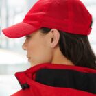 Person wearing a red mesh cap and jacket, viewed from the side.