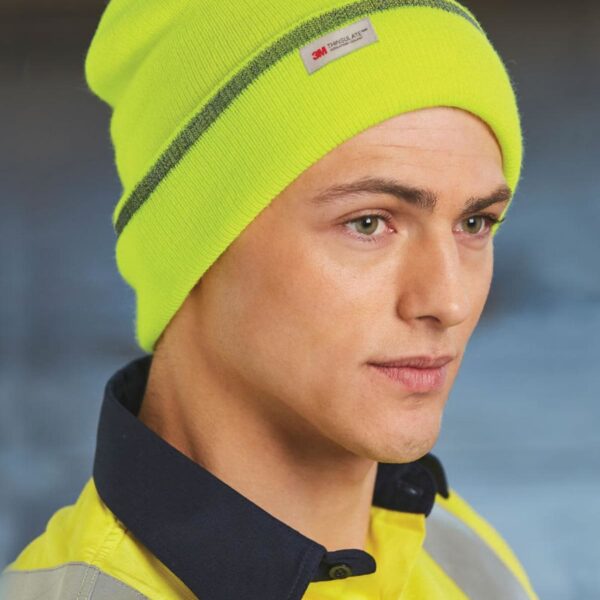 Person in yellow beanie and jacket with a dark collar, looking to the side.