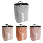 Four laundry baskets in gray, beige, orange, and pink, each with handles and LAUNDRY printed.