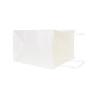 White paper shopping bag lying on its side against a plain background.