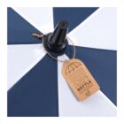 Close-up of a blue and white umbrella with a brown tag attached to the top.