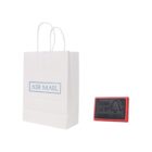 White paper bag labeled Air Mail next to a red and black rubber stamp.