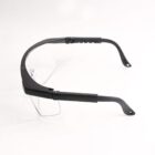 Safety glasses with adjustable black arms and clear lenses on a white background.
