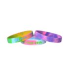 Three colorful silicone wristbands with various text and designs.