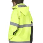 Person wearing a fluorescent yellow high-visibility jacket with reflective stripes and a hood, standing sideways. The jacket is paired with light blue jeans. The background is plain white.