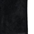 Close-up of a black fleece fabric with a visible zipper on the right edge.
