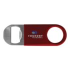A red bottle opener with a silver metal opener on the left and a circular handle on the right. The logo for Foundry Networks is printed in the center in white and multicolored text.