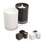 Two glass candles, one white and one black, with matching square boxes beside them.