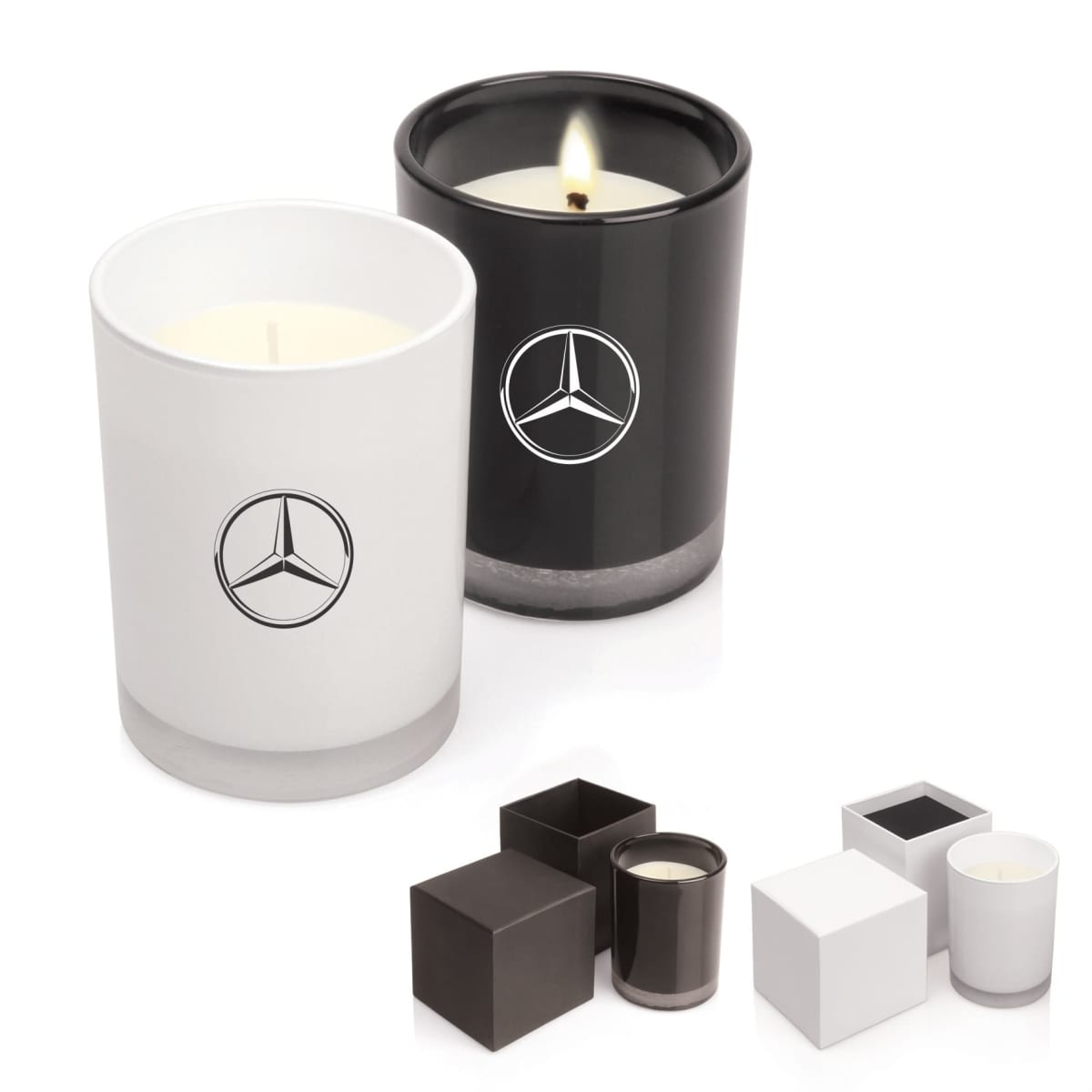 Two candles in black and white holders with Mercedes-Benz logos and matching square boxes.