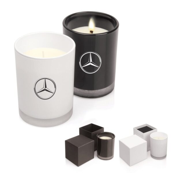 Two candles in black and white holders with Mercedes-Benz logos, next to their boxes.