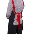 Person wearing a black apron with red straps, seen from behind.