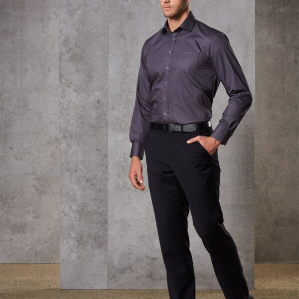 Man in formal wear standing against a gray concrete wall background.