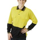 A young person poses with a hand on their hip, wearing a long-sleeve yellow and black polo shirt with buttoned pockets and dark jeans. They have short, light brown hair and smile at the camera against a white background.