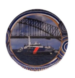 Decorative plate with a ship and bridge design, featuring blue and gold patterns.