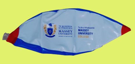 A deflated Massey University balloon on a yellow background.
