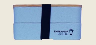 printed lunchbox with a black strap and Endeavour College logo.