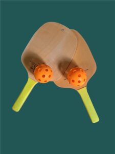 Promotional Pickleball Merch | Two wooden paddles with orange balls.