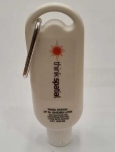 White bottle of SPF 30+ sunscreen lotion with a carabiner attached at the top.