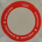 Red frisbee with MONEYQUEST HOME LOANS and a phone number printed in white.