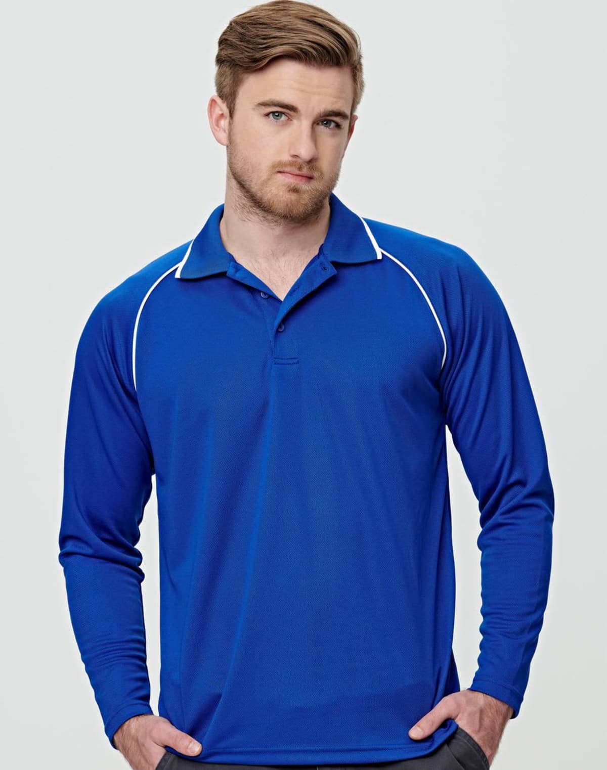 Person in a long-sleeve blue polo shirt with white accents, standing against a plain background.