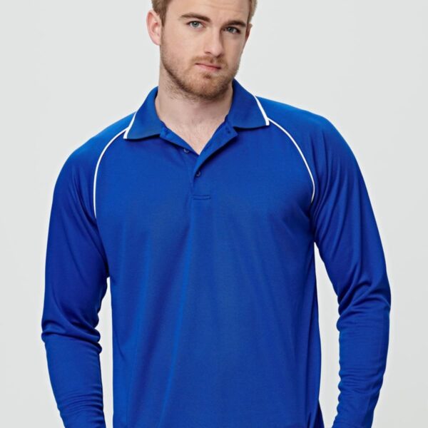Man wearing a blue long-sleeve polo shirt standing against a neutral background.