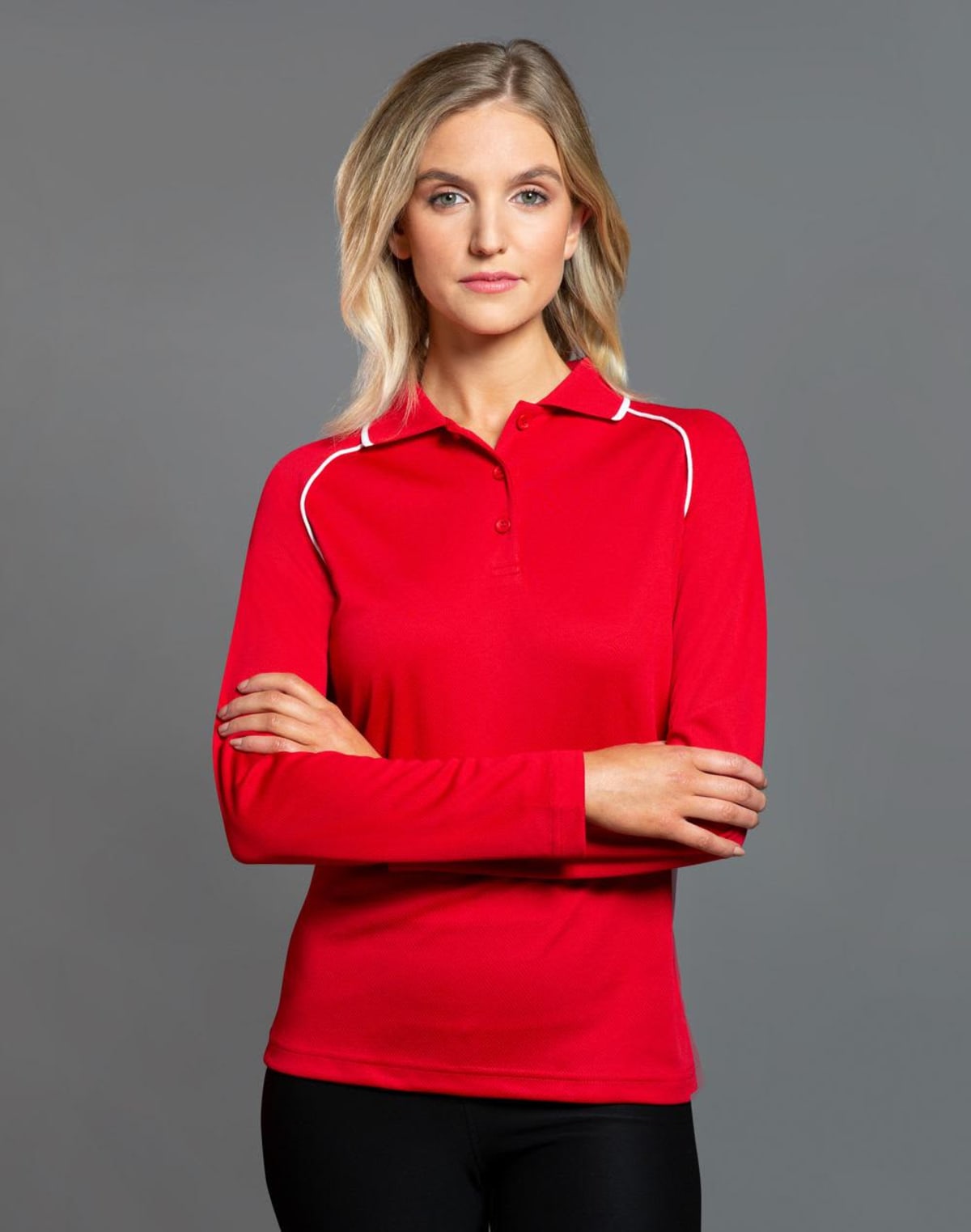 Woman in red long-sleeve polo shirt with arms crossed, neutral expression.