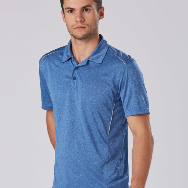 Man in a blue polo shirt stands against a plain background.